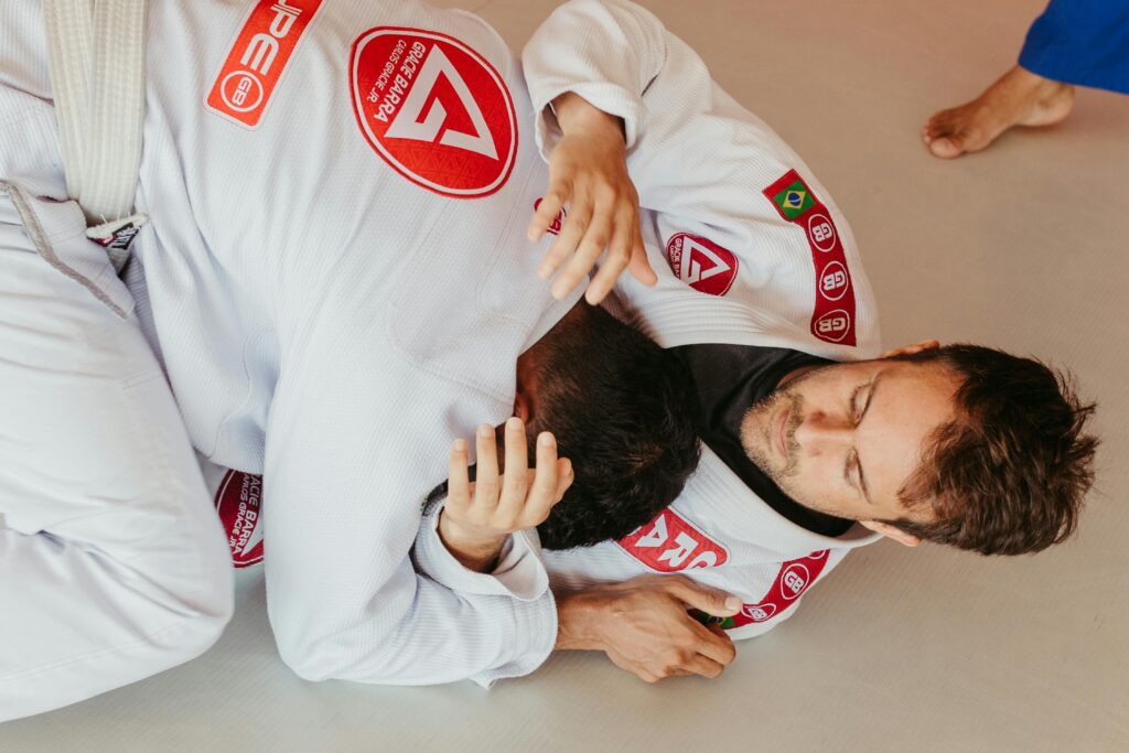 pexels photo 15545735 15545735 Two men engaging in a Brazilian Jiu-Jitsu match, showcasing grappling techniques from a top view perspective.